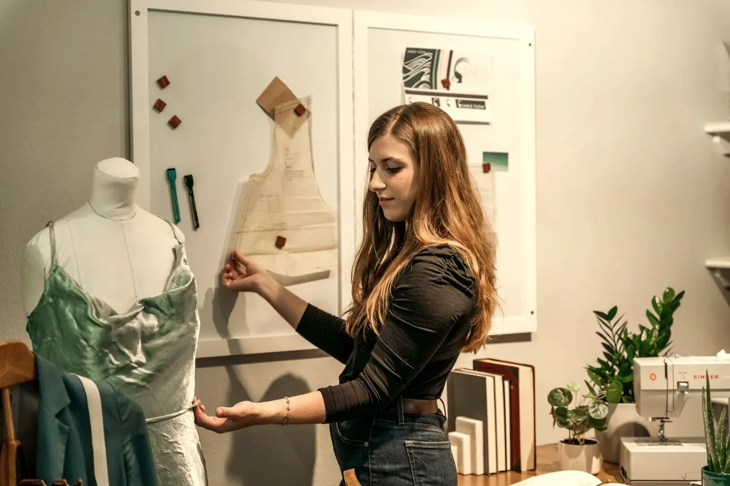 Une couturière présente une pièce en cours sur un mannequin dans un atelier lumineux.